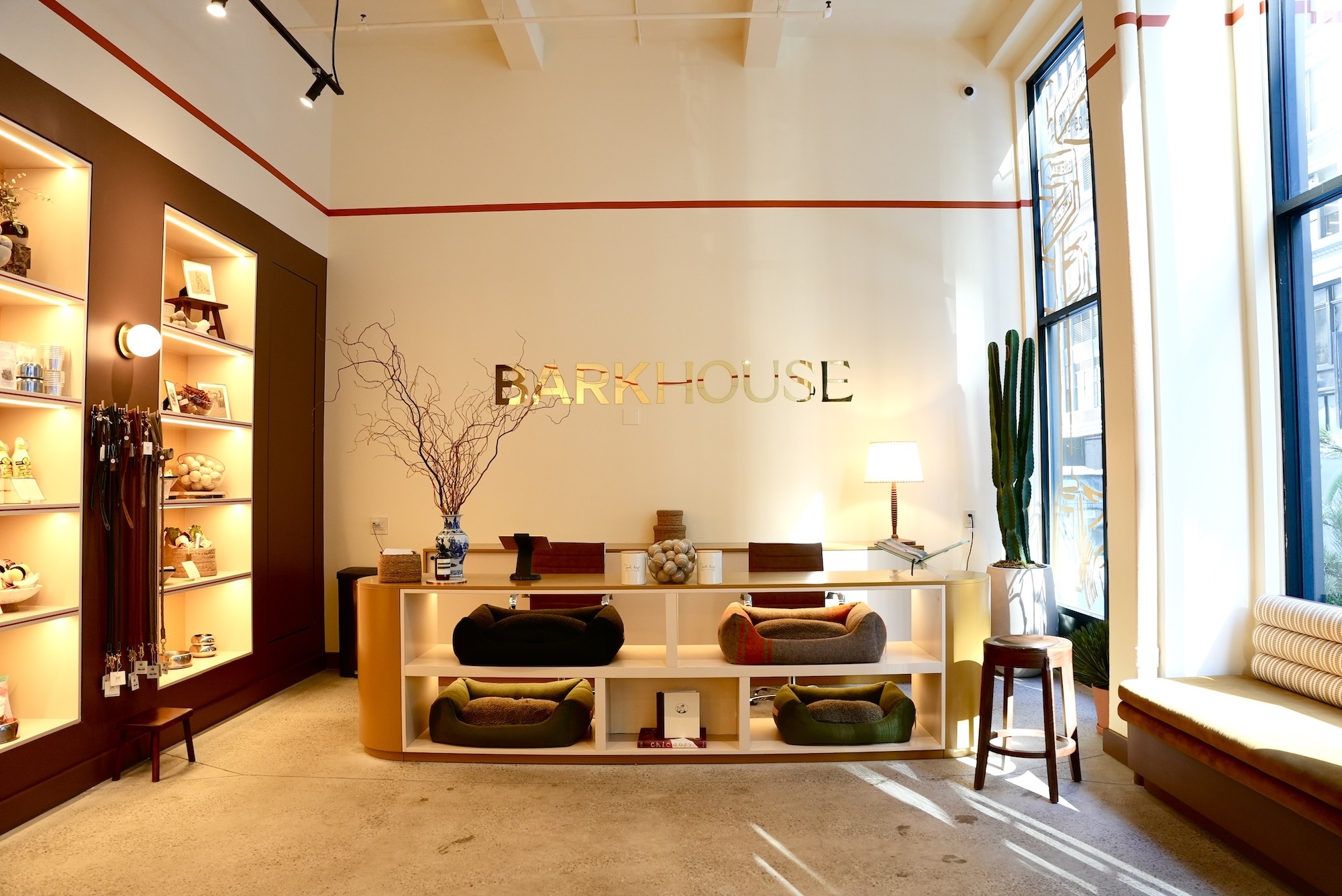 Interior of Barkhouse retail store featuring custom shelving, display counter with pet beds, and gold lettering on wall