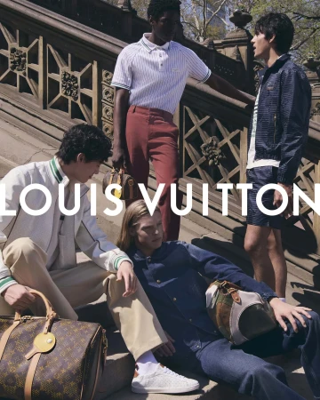 Four male models posing on stone stairs outdoors holding luxury monogram travel bags for Louis Vuitton