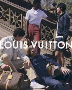 Four male models posing on stone stairs outdoors holding luxury monogram travel bags for Louis Vuitton