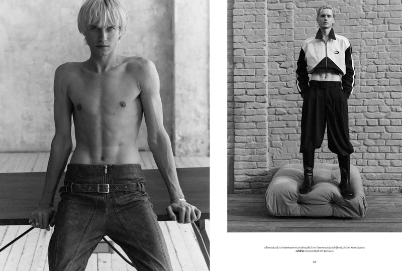 Black and white editorial double-page spread featuring a male model with blonde hair posing shirtless on the left and standing on a low cushion on the right.