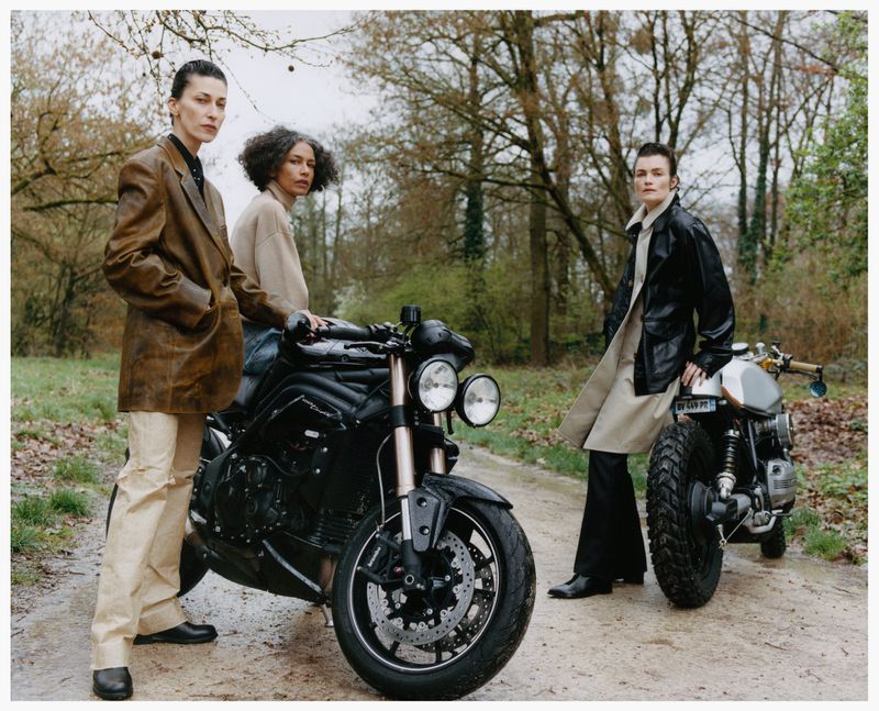 Three models posing outdoors with motorcycles on a wooded path for the Family Style editorial Man vs. Machine