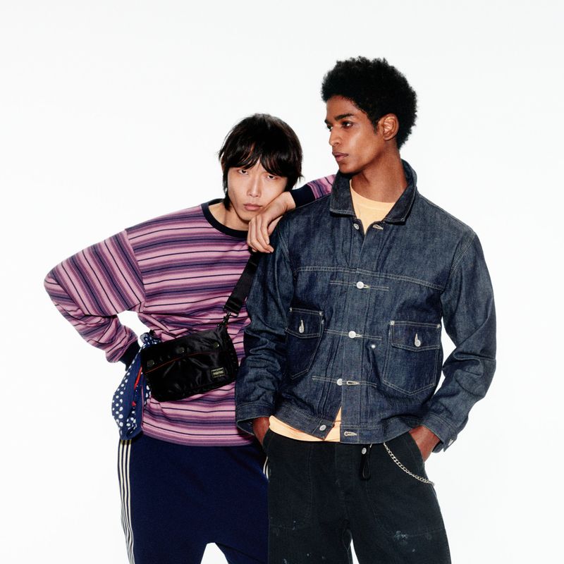 Two male models posing against a white background for the Mr Porter Made in Japan project, wearing a striped sweater and denim jacket.