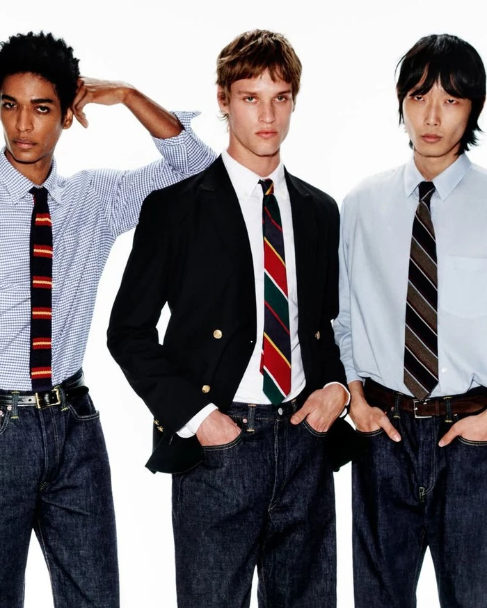 Three male models wearing button-down shirts, ties, and dark denim jeans against a bright white background for Mr Porter.