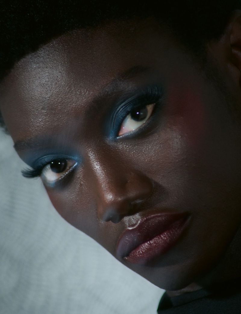 Close-up portrait of a Black model with dark blue eyeshadow and styled makeup for System Collections Autumn Winter 2026-2027.