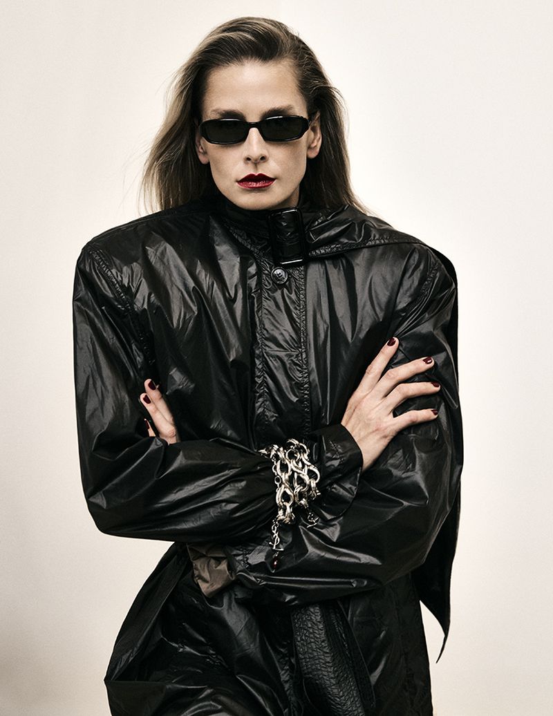 Model Hana Soukupova wearing a black coat and dark sunglasses against a seamless white background for Harper's Bazaar España.