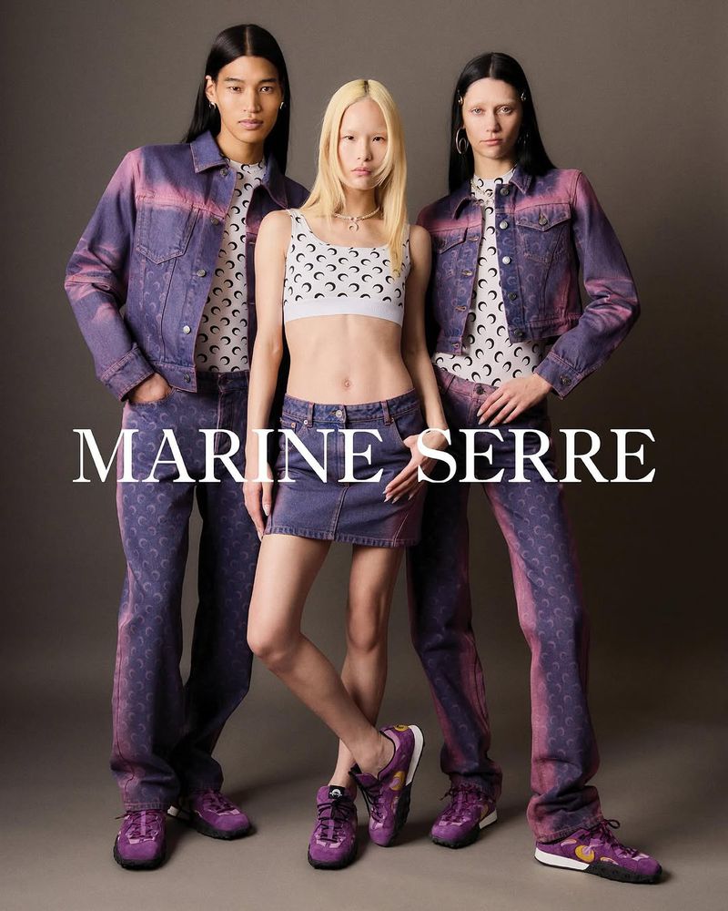 Three fashion models showcase a new denim clothing line with printed crescent moon designs, set against a neutral gray background.