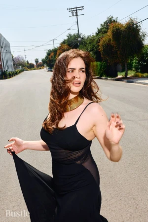 Barbie Ferreira wearing a black dress and gold choker on an asphalt street for Bustle Magazine
