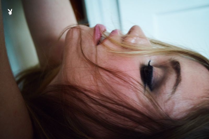 Close-up profile portrait of Lexee Smith lying down with loose hair falling across her face captured by Morgan Maher for Playboy.