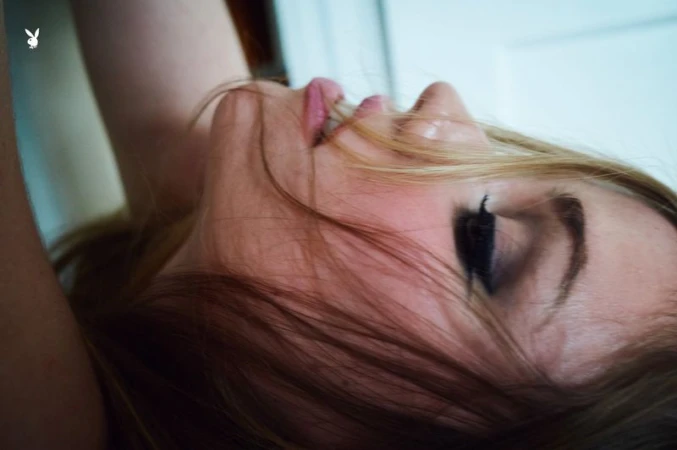 Close-up profile portrait of Lexee Smith lying down with loose hair falling across her face captured by Morgan Maher for Playboy.