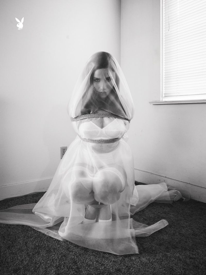 Model Lexee Smith kneeling in a sheer white veil and dress for a Playboy editorial photographed by Morgan Maher