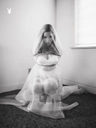 Model Lexee Smith kneeling in a sheer white veil and dress for a Playboy editorial photographed by Morgan Maher