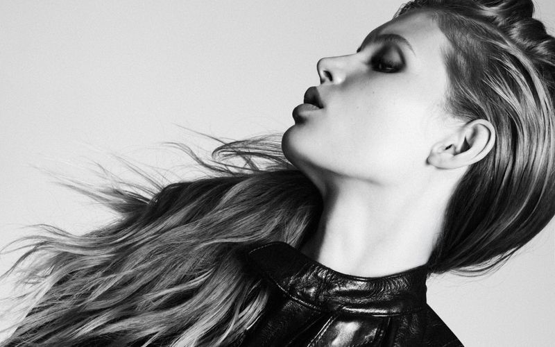 Profile portrait of model Ida Heiner with windswept hair wearing a dark leather jacket against a plain light background