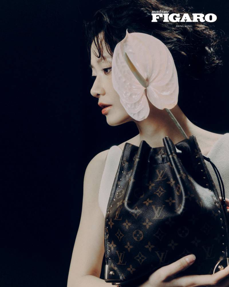 Woman holding a white anthurium flower and monogram bucket bag for Madame Figaro Hong Kong editorial