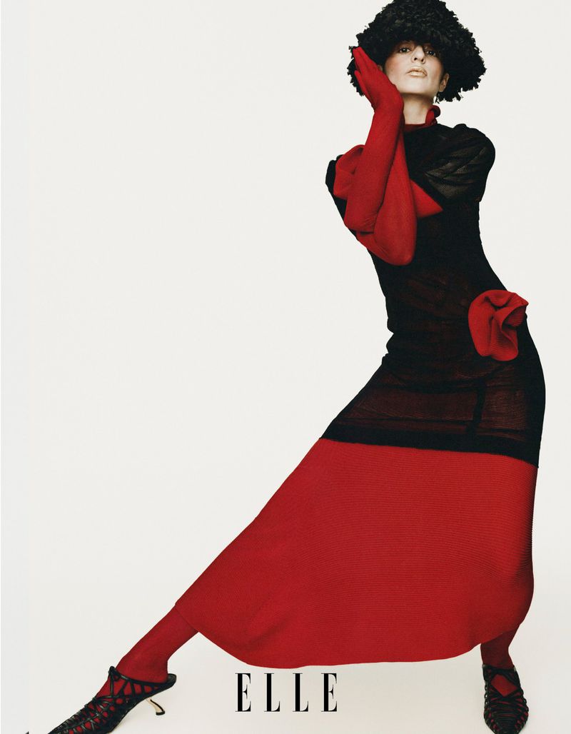 Model Aoife Lou in a black dress with red gloves and skirt against a seamless white background for Elle China editorial.