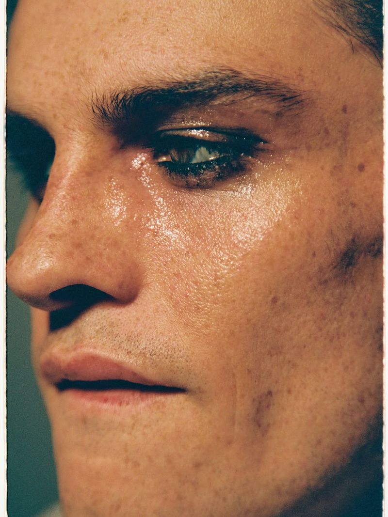 Close-up portrait of a male model with freckles and dark eye makeup for Numero Netherlands editorial photography by Benjo Arwas