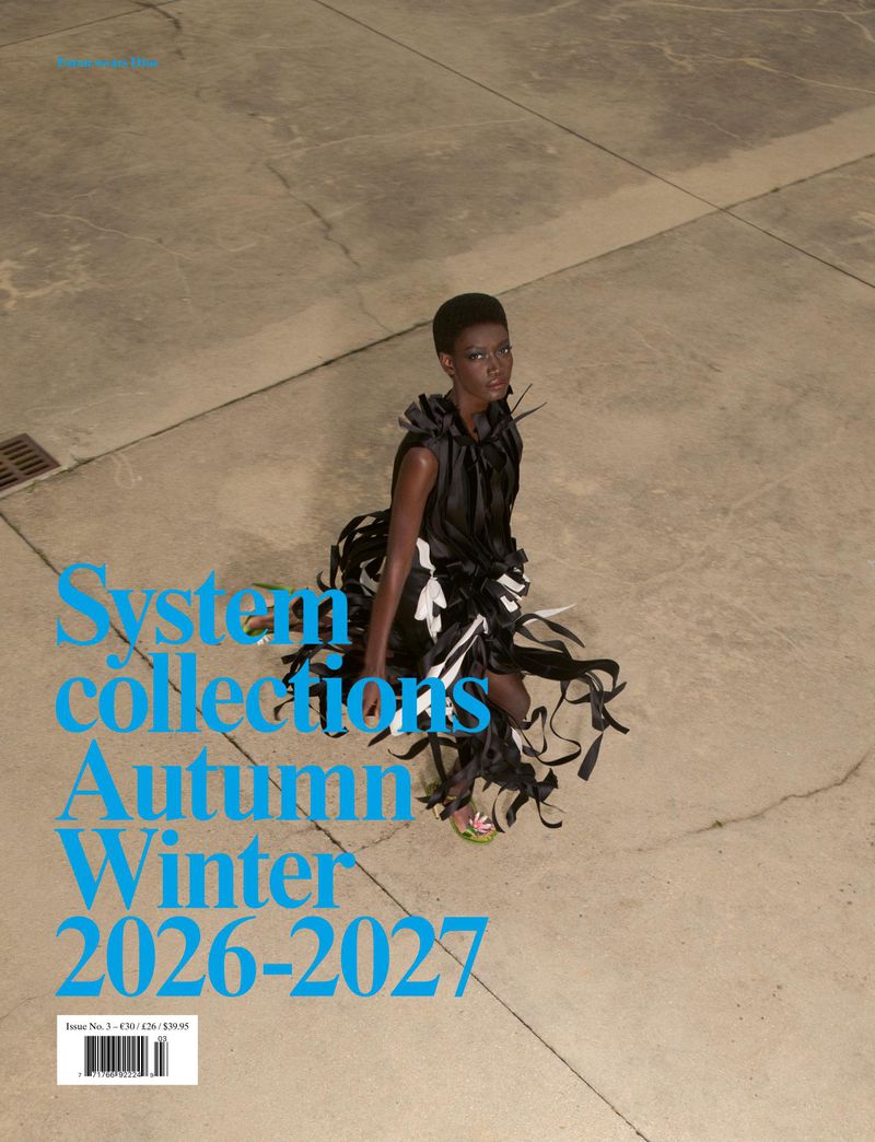 Model in black ribbon dress standing on concrete ground from high angle view with blue typography