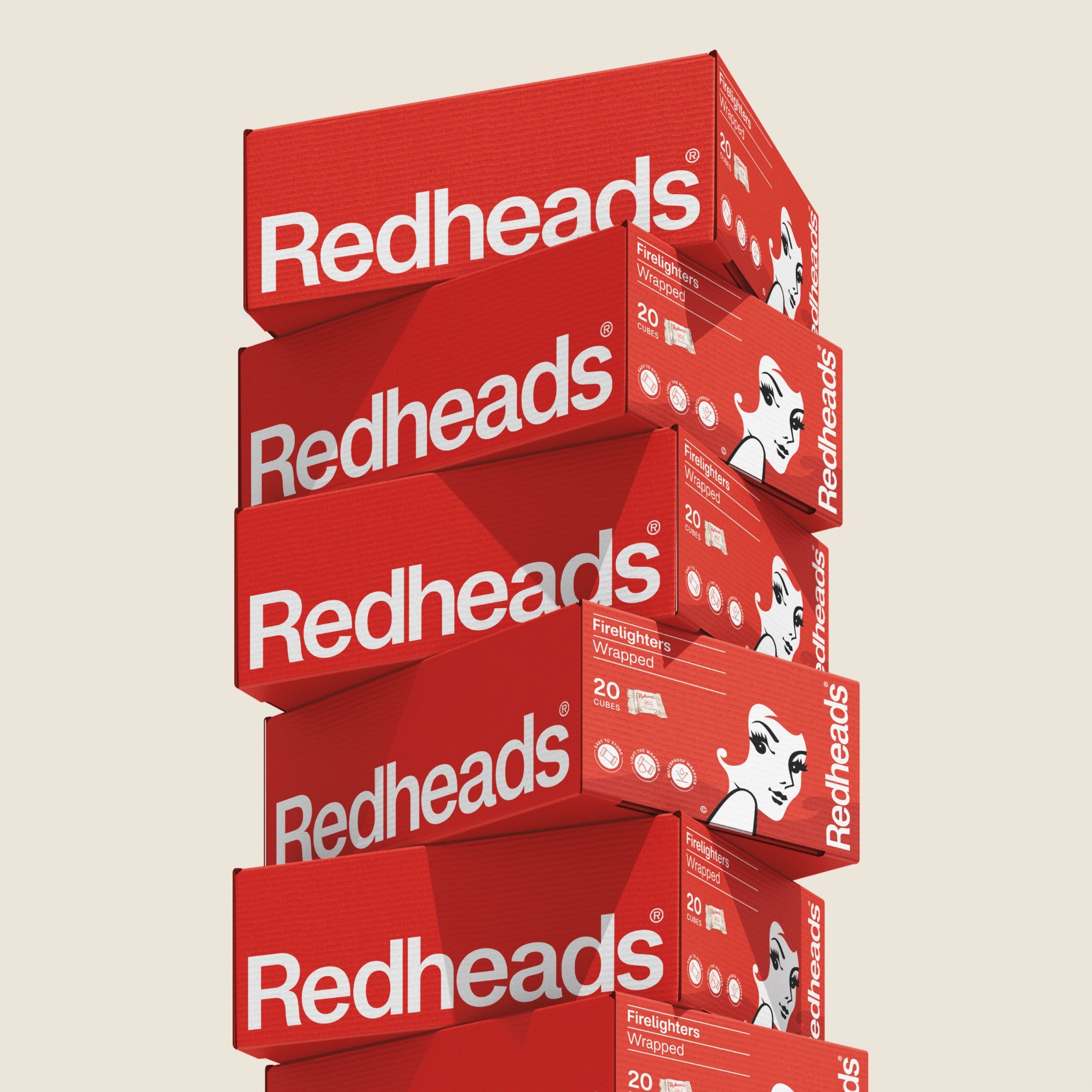 Stack of bright red Redheads firelighter boxes featuring bold white typography against a clean neutral background