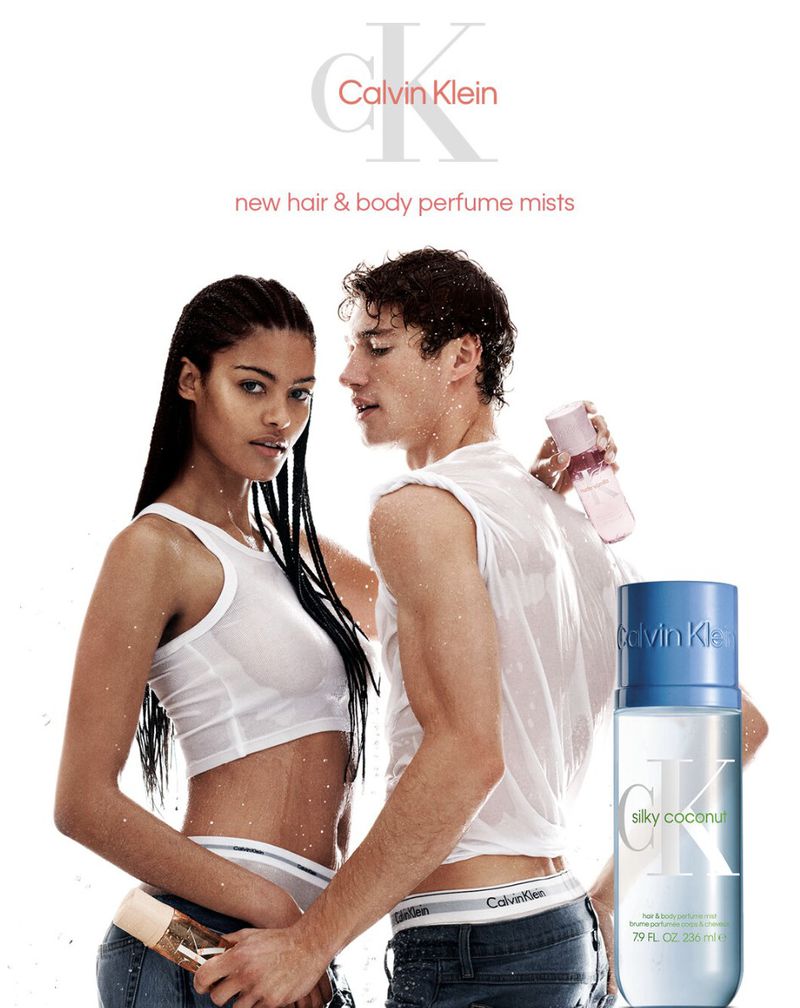 Calvin Klein advertisement featuring two models wearing white tank tops and holding body mist bottles against a white background