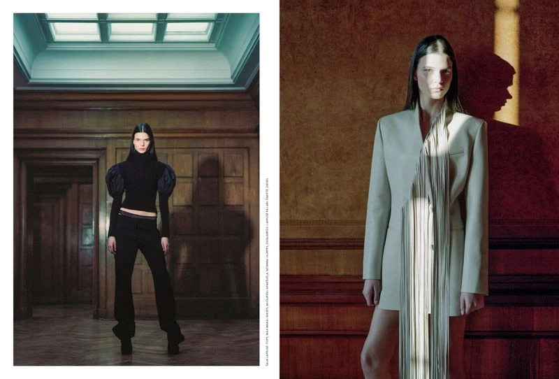 Fashion editorial featuring a slender female model posing indoors in a dark turtleneck and pants, and a light-colored fringe jacket.