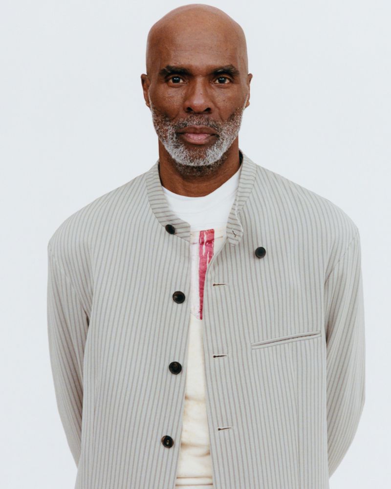 Portrait of a mature Black man wearing a striped jacket against a plain white background