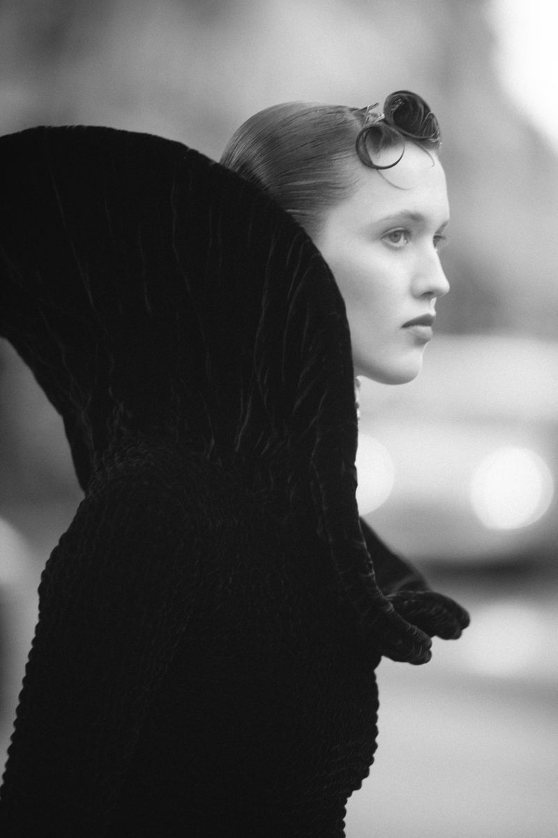 Monochrome profile portrait of a woman wearing a dark high-collared velvet garment for Elle Hungary
