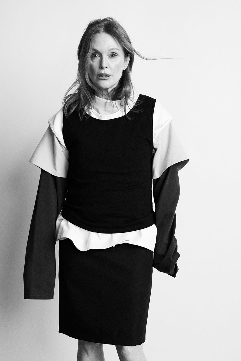 Julianne Moore wearing layered black and white garments against a plain white studio background.