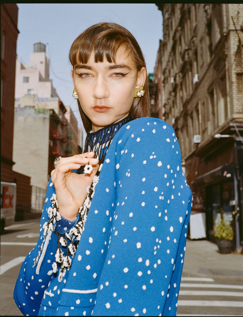 Model wearing a patterned blue jacket on an urban street for SCMP Style magazine