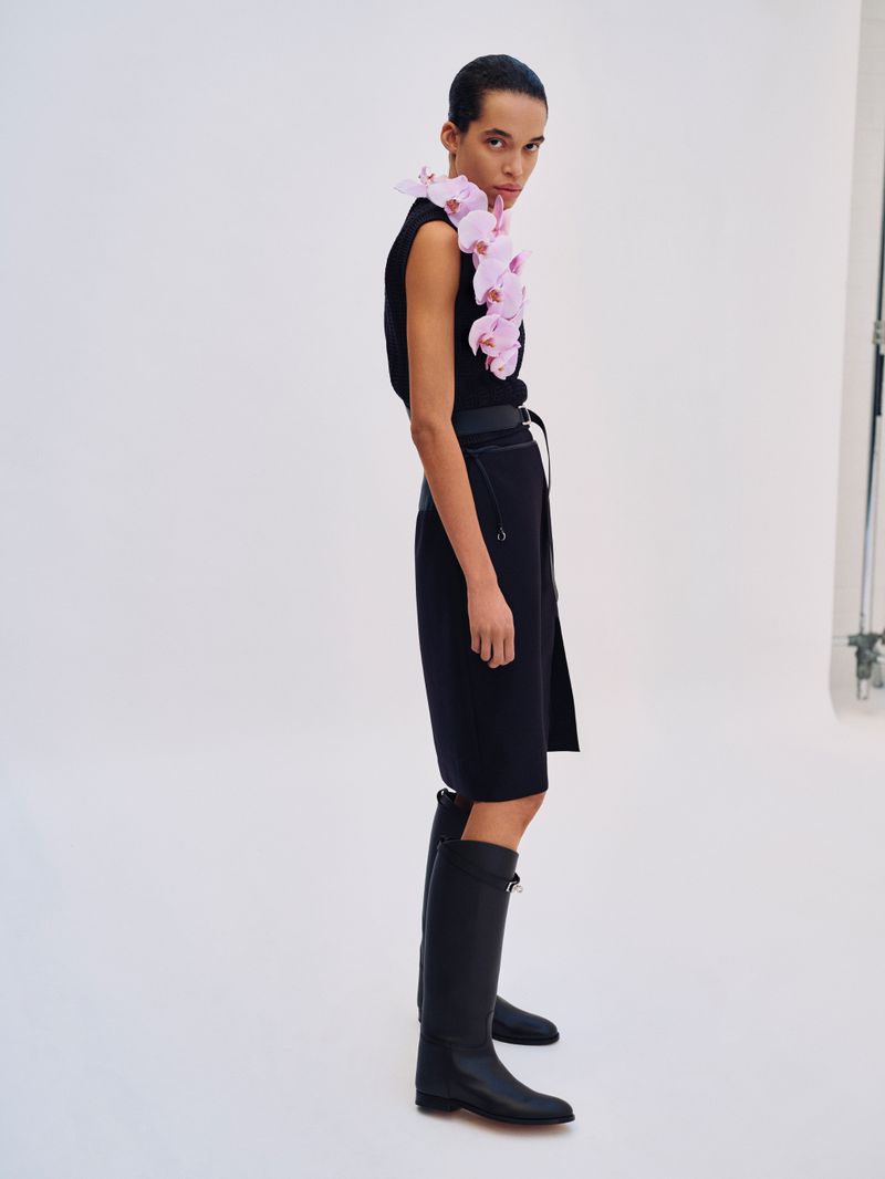 Model Lara Menezes wearing a black outfit adorned with pink orchids for Exit Magazine Black Orchid editorial