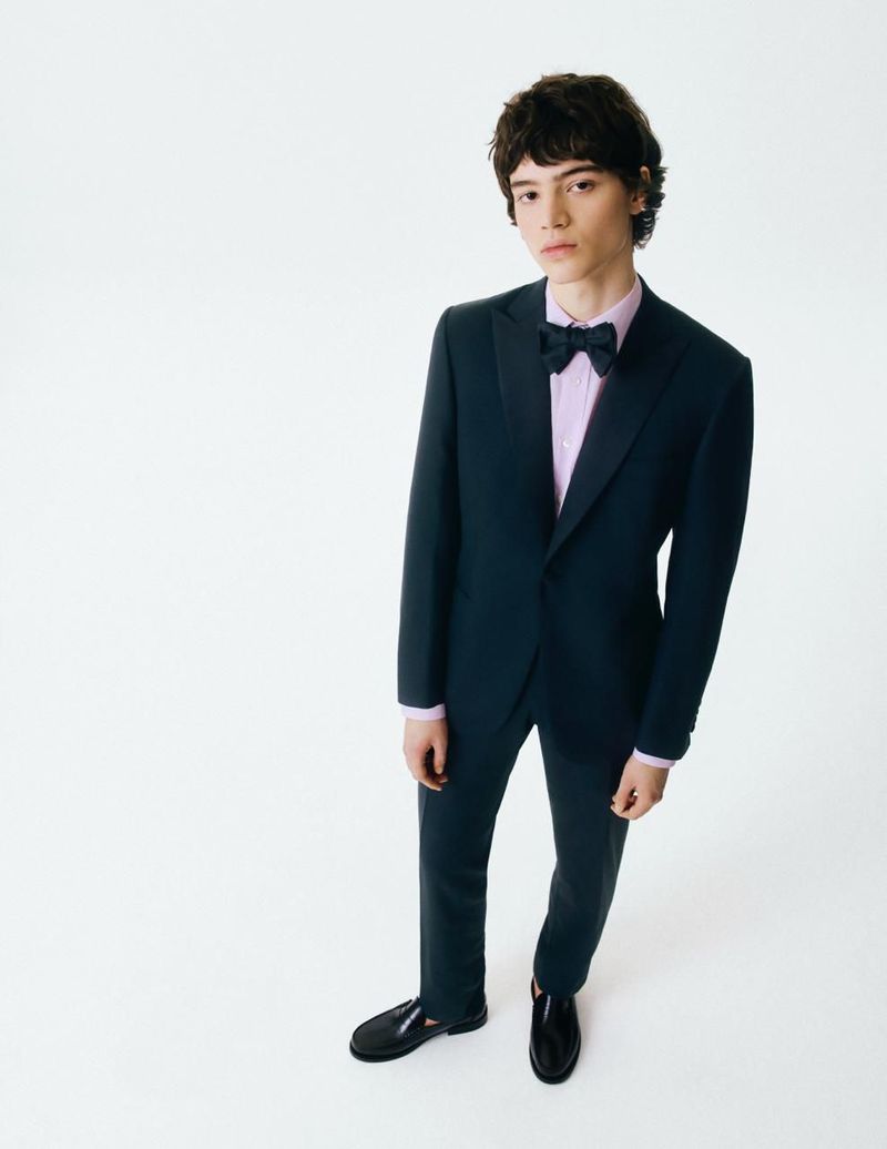 Model Bo Van der Vloet in a dark suit, pink shirt, and bow tie against a white background for L'Etiquette Magazine.