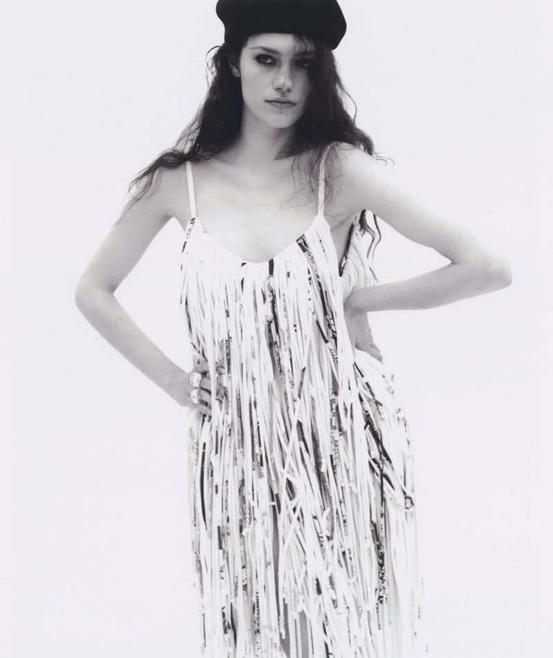 Model wearing a fringed dress and black beret against a white background for Silhouette Magazine editorial