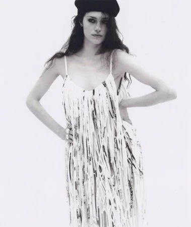 Model wearing a fringed dress and black beret against a white background for Silhouette Magazine editorial