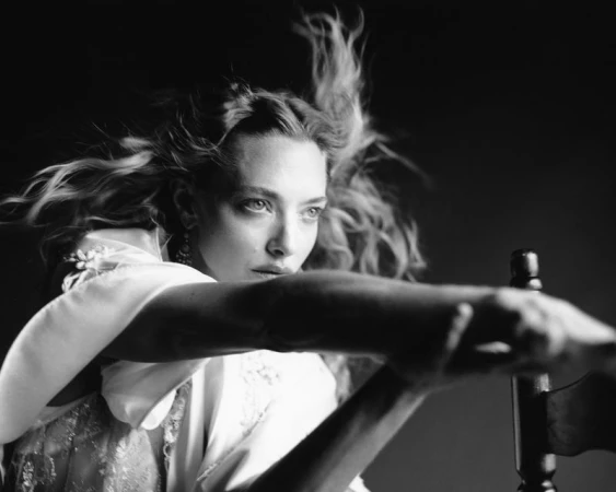 Black and white portrait of actress Amanda Seyfried with hair in motion, wearing a white garment, photographed by Eddie Wrey.