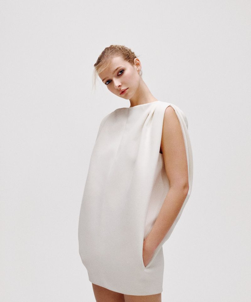 Apple Martin posing in a structured white dress against a plain white background for American Vogue photographed by Letty Schmiterlow.