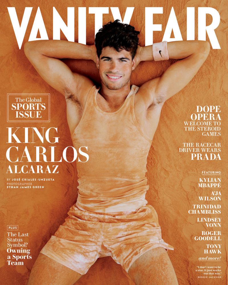 Vanity Fair magazine cover featuring Carlos Alcaraz wearing a tank top and shorts, laying on an orange-colored surface, smiling at the camera.