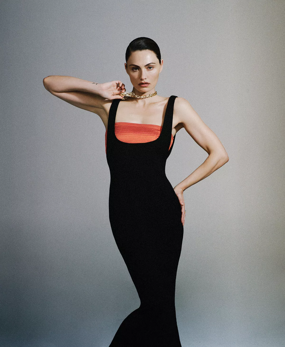 Phoebe Tonkin wearing a black dress and gold choker against a grey background for Harpers Bazaar Australia May 2026