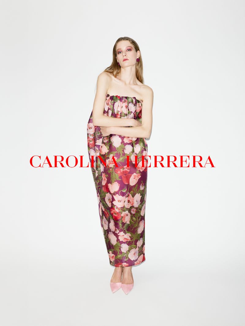 Model wearing a strapless floral print dress and pink heels against a plain white background with red typography