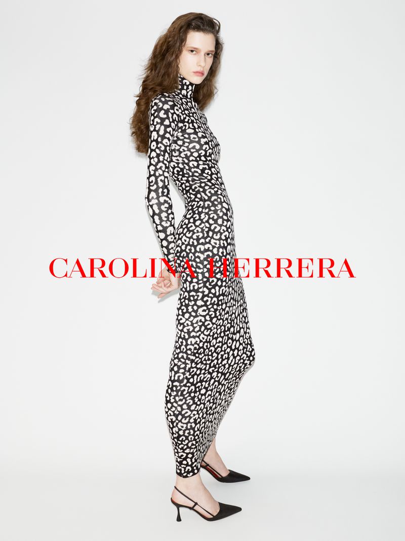Model wearing a long-sleeved black and white animal print dress against a plain white studio background.