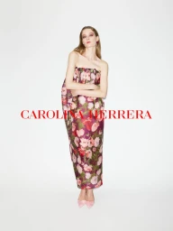 Model wearing a strapless floral print dress and pink heels against a plain white background with red typography