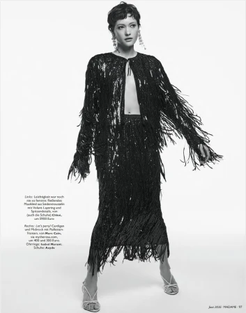 Model wearing a black sequined fringe cardigan and matching midi skirt against a plain studio background.