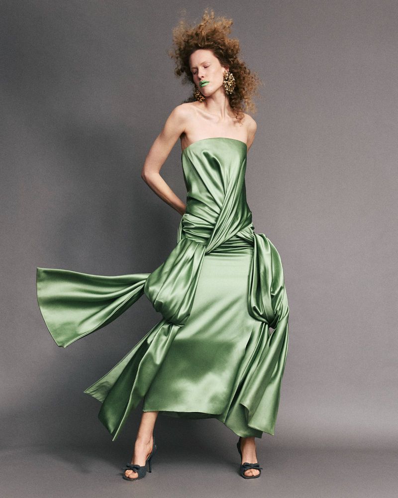 Model wearing a draped green satin strapless dress and heels against a dark grey seamless studio backdrop for Numero Istanbul.