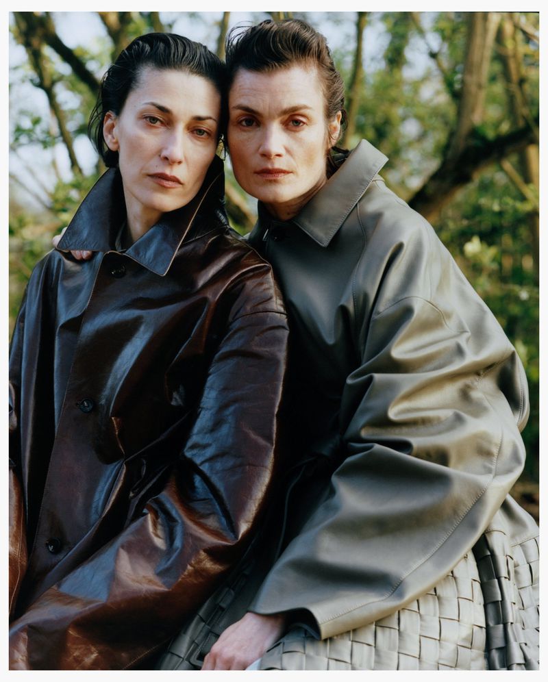 Two women wearing leather coats posing closely outdoors against a blurred background of trees for Family Style project Pressure Release