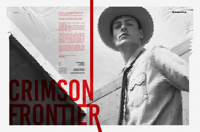 Low-angle monochrome editorial image of a male model wearing a wide-brim hat and patterned shirt against an abstract background