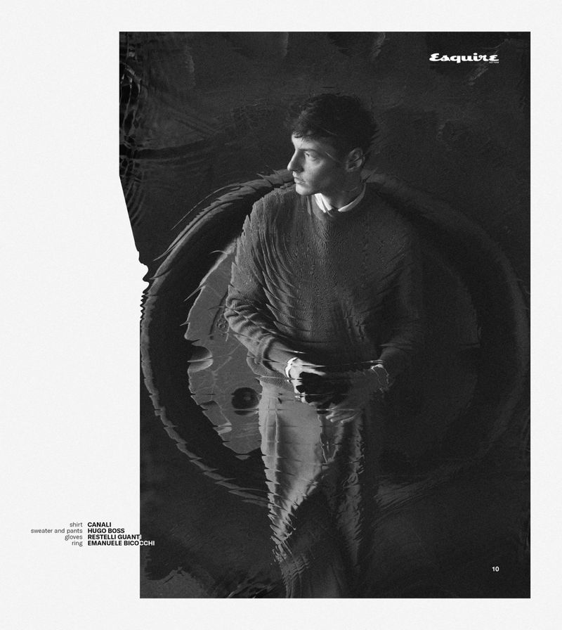 Black and white editorial fashion portrait of a man in a textured sweater against a dark patterned backdrop for Esquire Vietnam