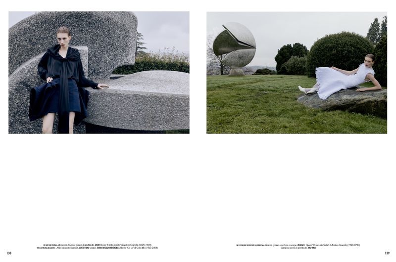 Double-page fashion editorial spread featuring two models posing outdoors with large modern outdoor sculptures for L'Officiel Italia.