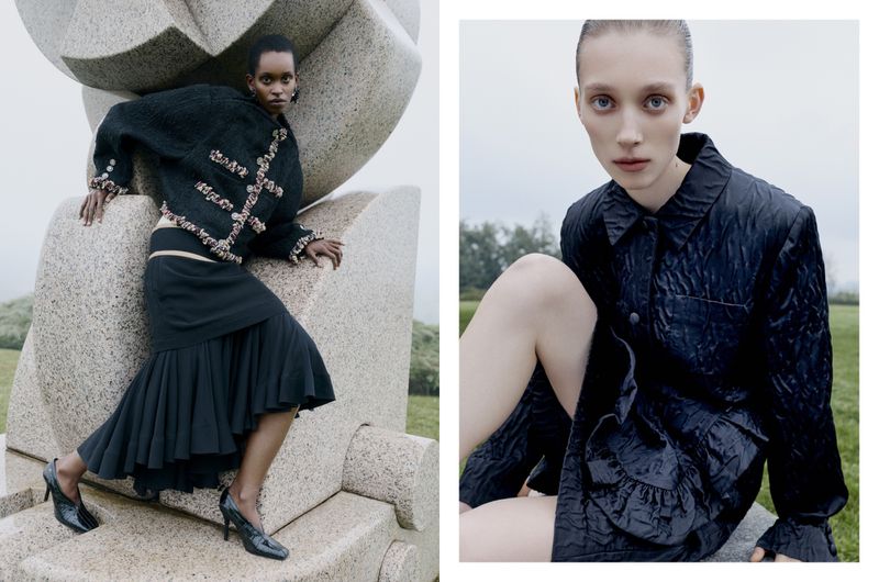 Two female models posing outdoors next to large stone structures in dark textured coats for L'Officiel Italia.