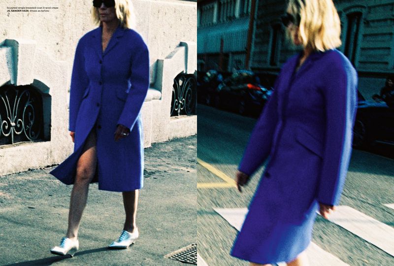 Kim Gordon wearing a blue wool crepe coat and metallic shoes walking on an urban street for AnOther Man Magazine.