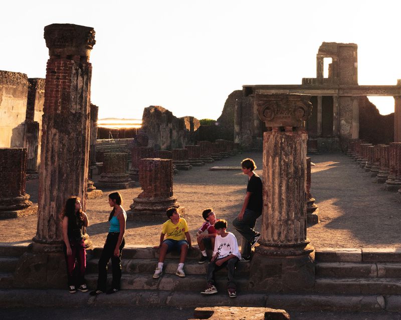 Group of youths gathered among ancient stone ruins at sunset for The Kids of Pompeii by EPOCH REVIEW