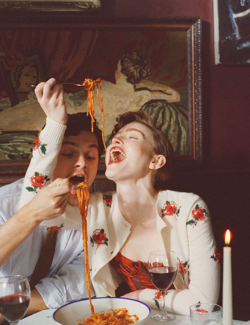 Sadie Sink and Noah Jupe eating pasta playfully in a restaurant for British Vogue, photographed by Polly Brown.