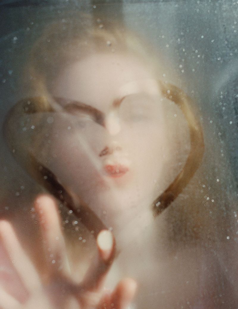 Sadie Sink pressing hand against a misted, condensation-covered glass surface in a portrait for British Vogue