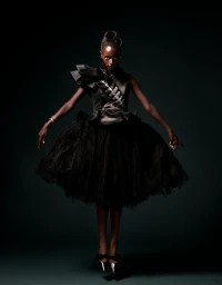 Model floating in mid-air wearing a sculptural black ruffled satin dress with a voluminous tulle skirt against a dark background.